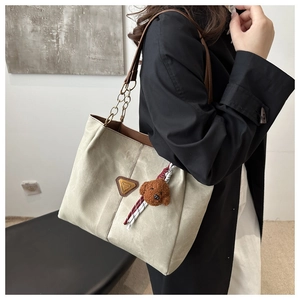 Détail du cabas vert olive avec bandoulière chaîne et breloque peluche caniche marron