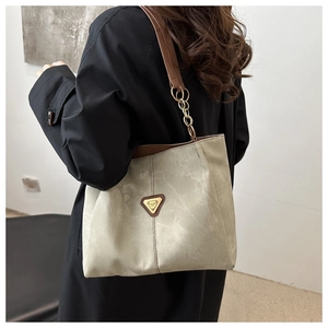 Détail du sac cabas minimaliste avec texture mate vintage et bandoulière dorée