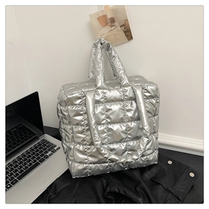 Detail of silver quilted puffer tote bag with high-shine metallic finish for women