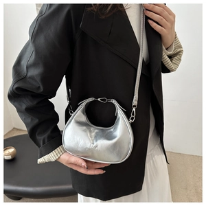 Detail of silver half-moon crossbody bag showing metallic texture and brand logo