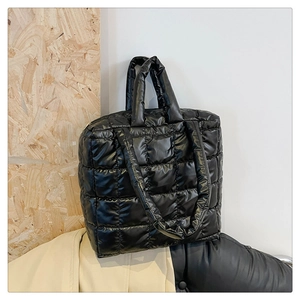 Close-up of the glossy black quilted puffer tote bag with puffy square stitching patterns