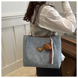Sac fourre-tout bleu mat avec bandoulière cuir et chaîne et pendentif ours