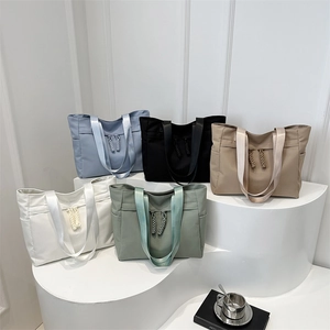 Minimalist nylon tote bags in various colors on display stands for daily commute