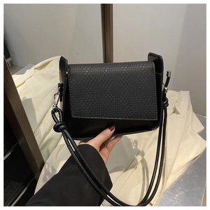 Detail of black PU crossbody bag showing woven texture cover and silver metal hook
