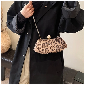 Détail d'une pochette léopard avec chaîne dorée et fermoir à perles élégant sur le sac