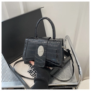 Détail du sac à main brillant motif crocodile avec fermoir ovale en métal argenté