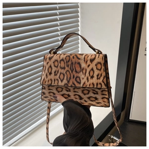 Gros plan détaillé du sac à main léopard avec fermoir doré et texture en fausse fourrure