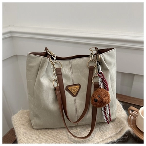 Détail du grand sac cabas avec chaînes dorées et adorable breloque ours en peluche marron