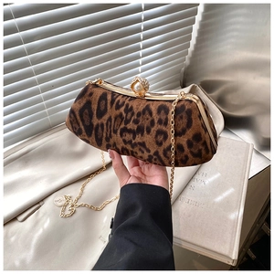 Détail macro d'une pochette léopard avec cadre doré et grand fermoir perle