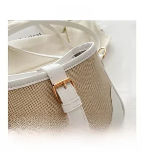 Detail of contrast stitching, woven texture, and golden buckle on this women's shoulder bag