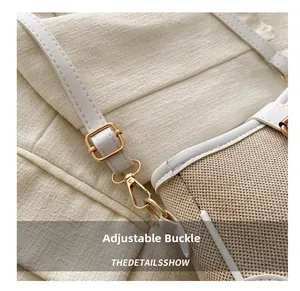 Close-up of golden adjustable buckle and strap on woven cream underarm bag