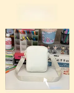 Détail de la bandoulière large et épaisse sur sac à bandoulière crème pour confort