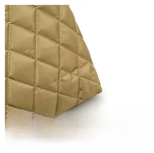 Detailed close-up of khaki quilted fabric with high-quality diamond stitch patterns