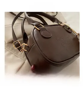 Gros plan d'un sac à main marron vintage avec lettrage gaufré et détails dorés