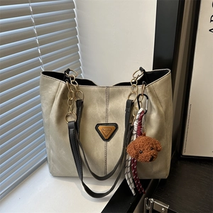 Sac fourre-tout beige chic avec bandoulières noires, chaîne dorée et pendentif chien