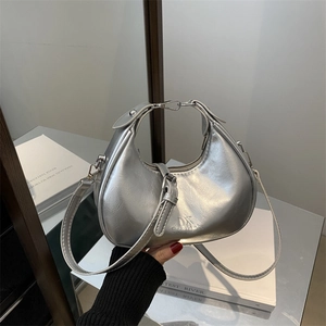 Silver metallic crescent handbag with adjustable strap and polished chrome texture