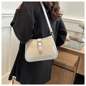Detail of a vintage-style beige canvas and blue leather crossbody bag with metal buckle