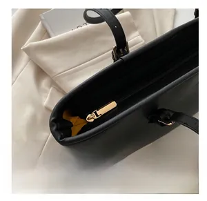 Dettaglio della cerniera dorata e fodera gialla su borsa tote nera in pelle Saffiano