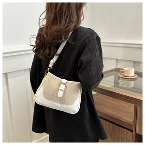 Detail of a color-block woven shoulder bag with a gold buckle and slim leather strap