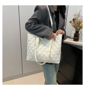 Close-up of a white quilted nylon tote bag with rhombus stitching and spacious design