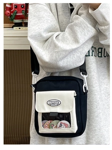 Détail du sac bandoulière en toile avec fenêtre transparente et badges de dessin animé
