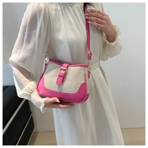 Detail of contrast stitch mini bag showing pink leather trim and gold buckle detail