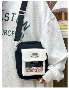 Vue détaillée du sac bandoulière en toile avec fenêtre transparente et badges de dessin animé
