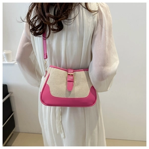 Detail view of contrast color shoulder bag with pink leather trim and canvas texture