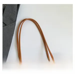 Detail of caramel brown lychee leather tote with blue and white floral scarf handle