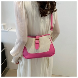 Close-up of pink PU leather and beige canvas stitching with gold buckle on shoulder bag