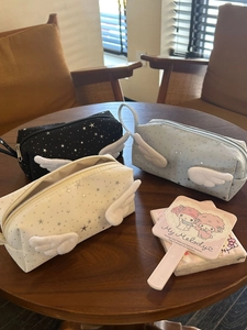 Detailed view of three starry pencil cases with plush angel wings and metal zippers