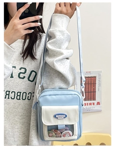 Détail du sac bandoulière en toile avec poche PVC transparente et badges colorés mignons
