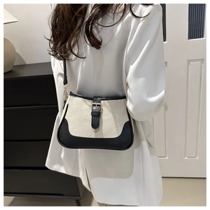 Detail shot of a retro contrast color canvas shoulder bag with black leather strap buckles