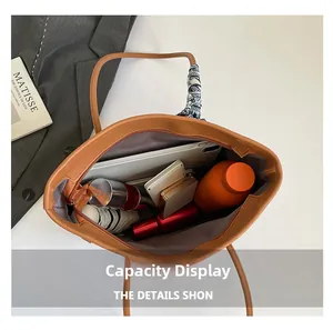 Detailed view of spacious brown tote interior with daily essentials and silk scarf handle