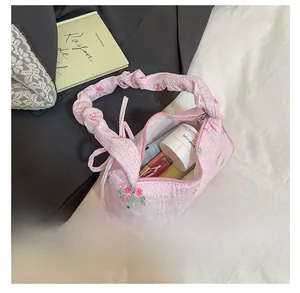 Detailed view of pink floral drawstring bag interior showing phone and lipstick storage