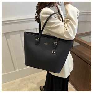 Dettaglio della borsa tote in pelle nera con logo dorato e fibbia alla moda