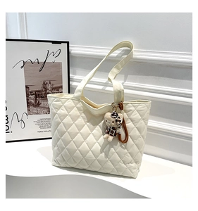 Detail of white quilted nylon tote bag with cute cartoon plush charm and large capacity