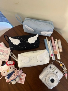 Detailed view of canvas star pencil pouches with plush wings and carry handles