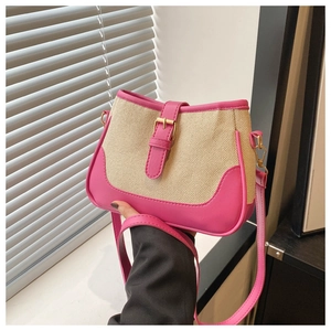 Close-up of contrast woven bucket bag with pink leather trim and buckle detail