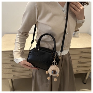 Détail du petit sac vintage en cuir noir avec gaufrage lucky OHIO et breloque lion