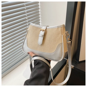 Close-up of contrast woven texture and silver metallic buckle on women's underarm bag