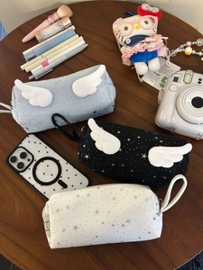Detail of three starry canvas pencil cases with 3D angel wings and silver star patterns