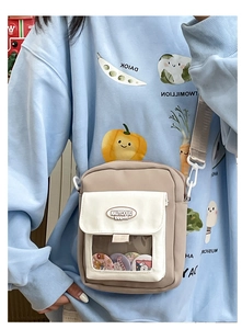 Détail du petit sac bandoulière kaki avec fenêtre transparente et badges mignons