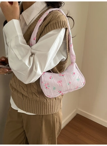 Detail of pink floral ruched hobo bag with textured fabric and vintage rose pattern