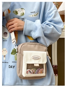 Détail de la poche avant transparente avec badges de dessin animé sur sac en toile