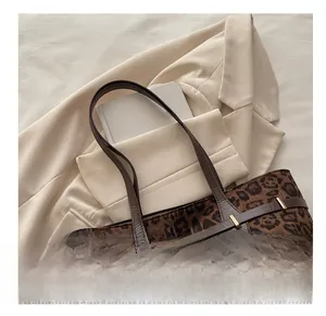 Vue détaillée du sac cabas à imprimé léopard avec anses en cuir brun et boucle dorée chic