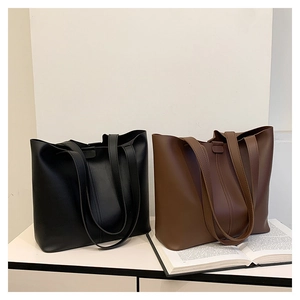 Detail view of large tote bags in black and brown with fine pebbled texture for commuting