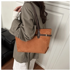 Détail du sac cabas en daim caramel avec bandoulières en cuir et accents en métal doré