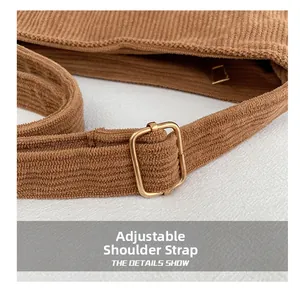 Adjustable shoulder strap detail on brown corduroy tote with gold metal buckle