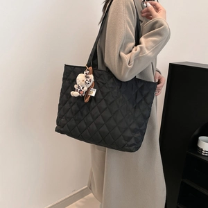 Chic black quilted tote bag for women featuring a stylish plush bear charm and large capacity